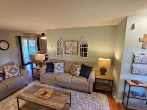 una sala de estar con 2 sofás y una cruz en la pared en Andrea Abode home, en Lexington