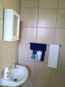a bathroom with a sink and a mirror and towels at Cosy Beds Web in eMalahleni