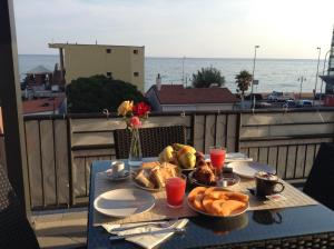 a table with a plate of food on a balcony at Villa Le Logge in Ventimiglia