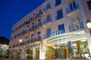 un edificio blanco con una tienda delante en Hotel Los Habaneros en Cartagena