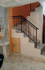 a staircase in a bathroom with a sink and a toilet at Elegance & Simplicity in Mombasa