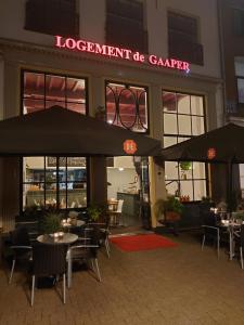 
a restaurant with tables and umbrellas in front of it at Hotel de Gaaper in Amersfoort
