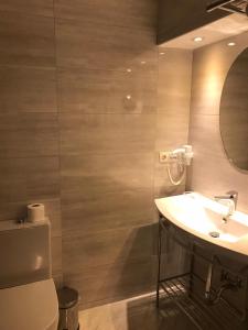 a bathroom with a toilet, sink, and mirror at Benler Otel Laleli ISTanbul in Istanbul