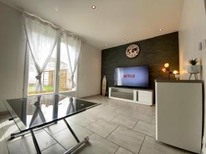 a living room with a tv and a glass floor at Maison Tommy in Carcassonne