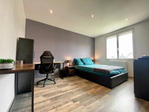 a bedroom with a bed and a desk with a computer at Maison Tommy in Carcassonne