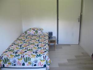 Un dormitorio con una cama con un edredón colorido. en Location& gîtes, en Sarrians