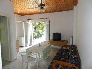 a living room with a table and a ceiling fan at Georgia in Nikiana