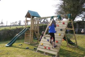 a girl and a boy playing on a playground at Tregolls Farm Cottages in Wadebridge