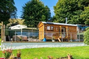 a tiny house on a fence in a yard at Honey Bee Shepherd's Hut - with Woodfired Hot Tub in Hawkshead