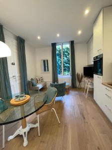 een woonkamer met een glazen tafel en stoelen bij Appartement François 1er in Vichy