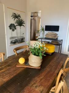 einem Holztisch mit einer Pflanze darüber in der Unterkunft Maison avec piscine chauffée - 8 personnes - Sud Réunion in Saint-Joseph