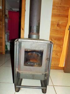 a metal stove sitting in a room with at Cabañas Aguas Claras in Pinto
