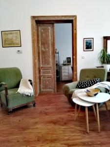 uma sala de estar com duas cadeiras e uma mesa em Šomin Lagum Vila em Sremski Karlovci