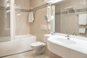 a bathroom with a toilet and a tub and a sink at NaturResidence Dolomitenhof in Siusi +24 photos