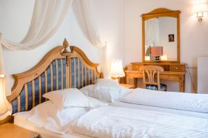 two beds in a bedroom with a desk and a mirror at NaturResidence Dolomitenhof in Siusi +28 photos
