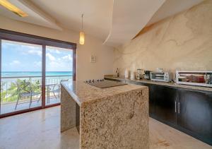 a kitchen with a counter with a view of the ocean at Condo Surf 407 - Beachfront Oceanview 1 Bedroom Condo Rental - at El Faro condos in Playa del Carmen