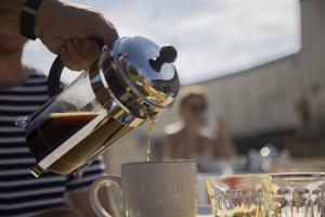 une personne verse du café dans une tasse dans l'établissement Villa Juno - Saint-Aubin-sur-Mer - Côte de nacre - Normandie - Plage débarquement, à Saint-Aubin-sur-Mer 32 autres photos