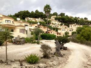 a group of houses on a hill with a dirt road at 4 persoons bungalow met gemeenschappelijk zwembad in Teulada