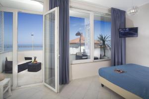 a bedroom with a bed and a view of the ocean at White Suite & Apartments in Bellaria-Igea Marina