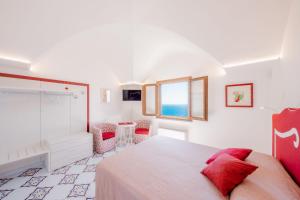 a bedroom with a bed and a table and a window at aLone Amalfi in Amalfi