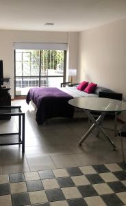 een slaapkamer met een groot bed en een tafel bij Departamento Céntrico Bariloche con patio in Bariloche