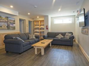 ein Wohnzimmer mit zwei Sofas und einem Couchtisch in der Unterkunft Gateside Chalets 6 Bedroom Hot Tub Near Village in Blue Mountains