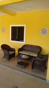 een woonkamer met 2 rieten stoelen en een tafel bij Pousada Maresia do Sargi in Uruçuca