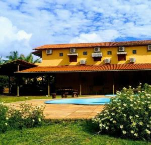 een huis met een zwembad ervoor bij Pousada Maresia do Sargi in Uruçuca