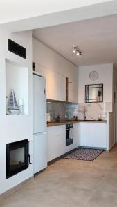 a kitchen with a white refrigerator and a fireplace at ISALO Villa in Makry Gialos