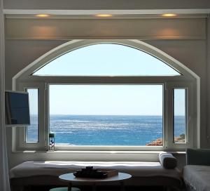 a living room with a large window with a view of the ocean at ISALO Villa in Makry Gialos
