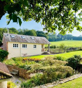a cottage with a garden in front of it at Burnhaies Farm Coach House in Cullompton