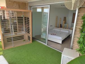 una habitación con cama y una habitación con alfombra verde en Exclusivo Apartamento Spa privado frente el mar, en Miami Platja