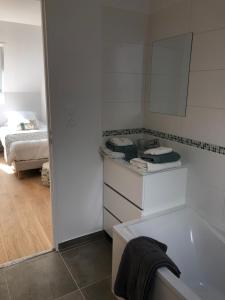 uma casa de banho com uma banheira e um quarto com uma cama em Gite 4 places, le Domaine de la Vallée em Saint-Martin-de-Varreville