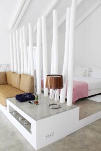 a white bedroom with a bed and a table at Casas da Lupa in Zambujeira do Mar
