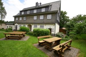 a group of picnic tables in front of a house at Fewo Alte Schule in Willingen