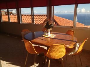 a dining room table with chairs and a view of the ocean at The Hill View House in Funchal