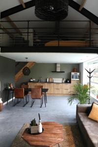ein Wohnzimmer mit einem Sofa und einem Tisch in der Unterkunft Met de Kippen op Stok - Vakantiehuisjes in Baexem