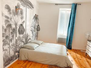 1 dormitorio con 1 cama con papel pintado tropical en Superbe T2 avec cours, en Carmaux