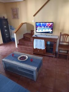 sala de estar con TV de pantalla plana y mesa en nueva el bosquin, en Nueva de Llanes