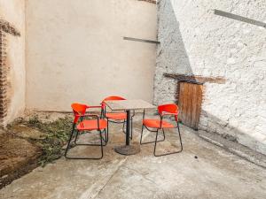 una mesa y cuatro sillas sentadas junto a una pared en Superbe T2 avec cours, en Carmaux