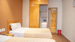 a bedroom with two beds and a door to a kitchen at Hotel Juarez in Mexico City