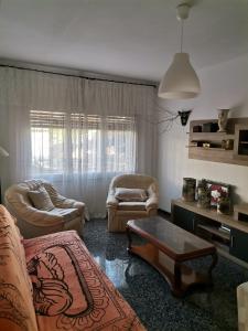 Una sala de estar con un sofá y sillas y una mesa. en Carrer Esparreguera, en Olot