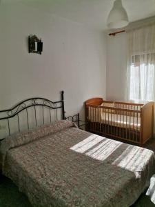 1 dormitorio con cama y cuna en Carrer Esparreguera, en Olot
