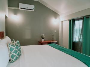 a bedroom with a white bed and a window at Airport Beach Hotel in Montego Bay