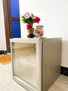 Elle comprend un petit réfrigérateur avec un vase de fleurs. dans l'établissement Lighthouse Guesthouse, à Nungwi