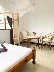 a bedroom with a bed and a ladder and chairs at Lighthouse Guesthouse in Nungwi +42 photos