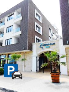 a building with a car parked in front of it at APART-HOTEL Stamopolu Lux с изглед към морето in Primorsko