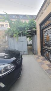 a black car parked in front of a garage at Дом в Хырдалане in Xirdalan
