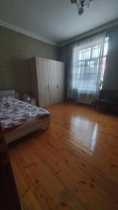 a bedroom with a bed and a wooden floor at Дом в Хырдалане in Xirdalan