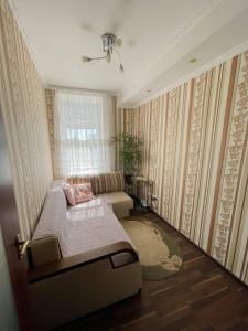 um pequeno quarto com uma cama e uma janela em Апартаменти ''Комфорт'' em Kamianets-Podilskyi